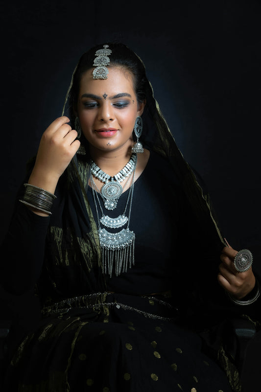 a woman in a black sari and jewelry