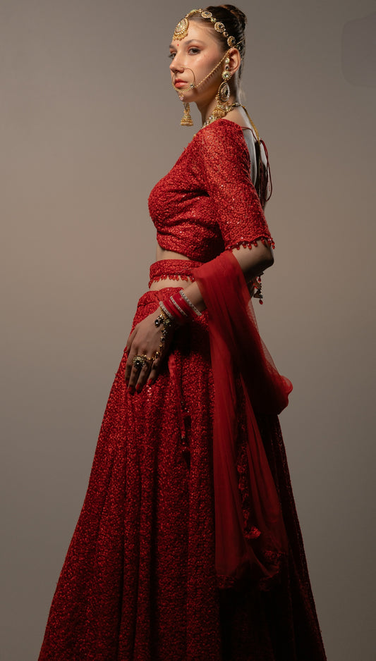 Woman models a beautiful red indian outfit.