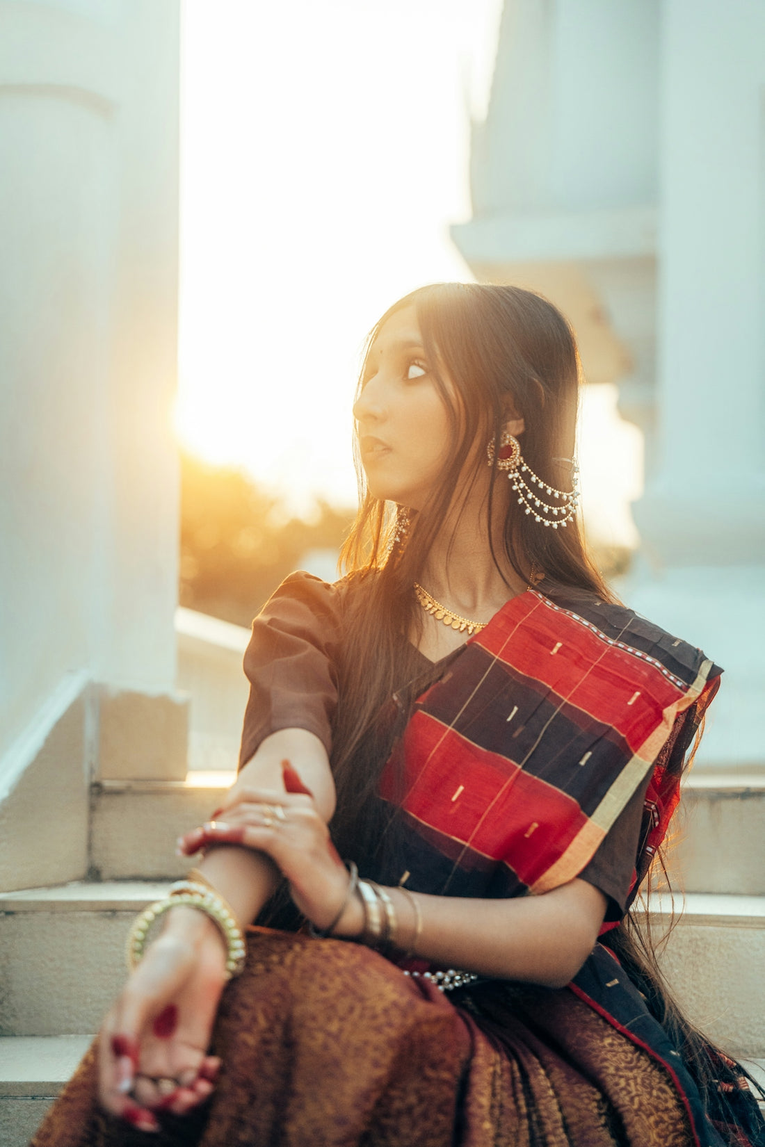 Woman in traditional indian attire sits on steps