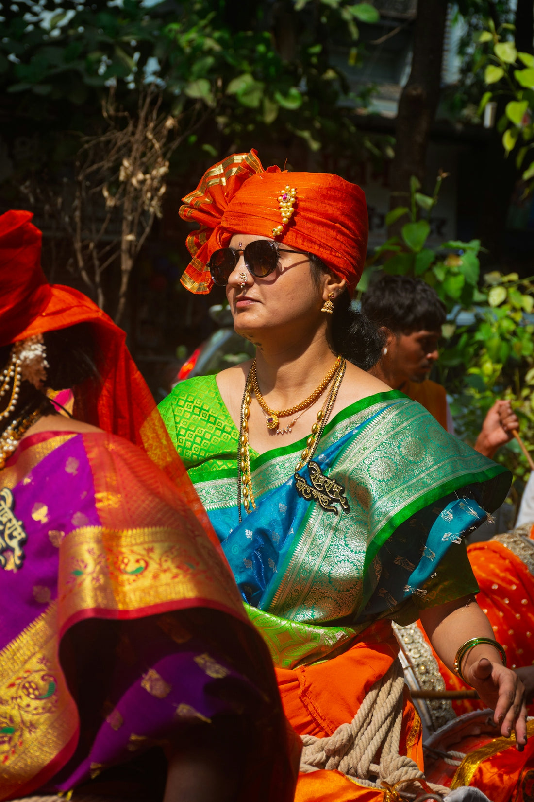 Woman in traditional indian attire with orange turban.