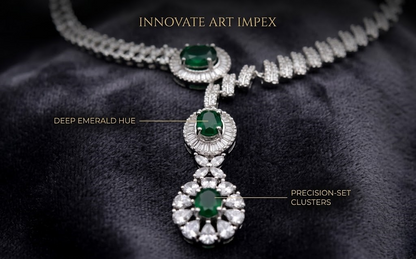 Elegant necklace with emerald stones and diamond clusters on a dark fabric background, featuring 'Innovate Art Impex' branding.