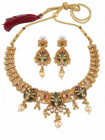 Close-up of INNOVATE ART IMPEX traditional gold Rajwadi choker necklace and matching dangle earrings featuring green floral enamel work, red stones, and pearl drops on a white background.