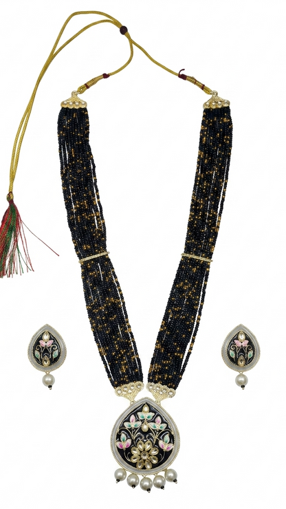 Black beaded necklace with silver floral pendants on a white background