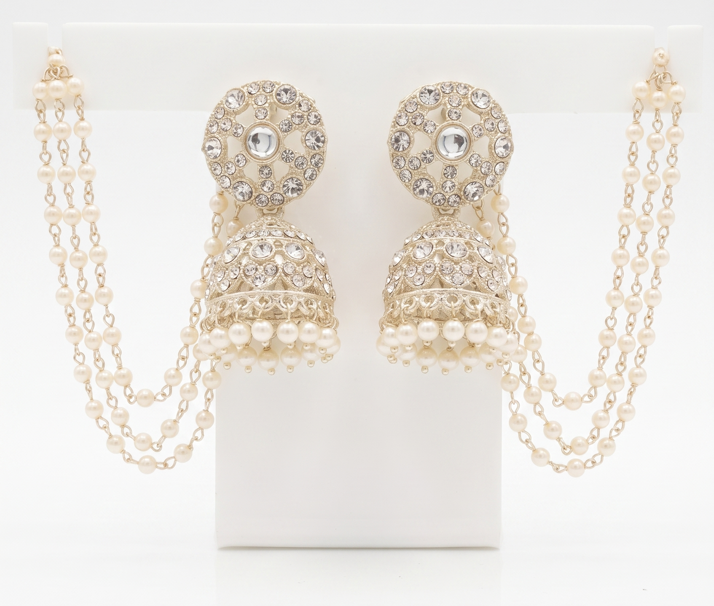 Pair of gold and pearl earrings with chains on a white background