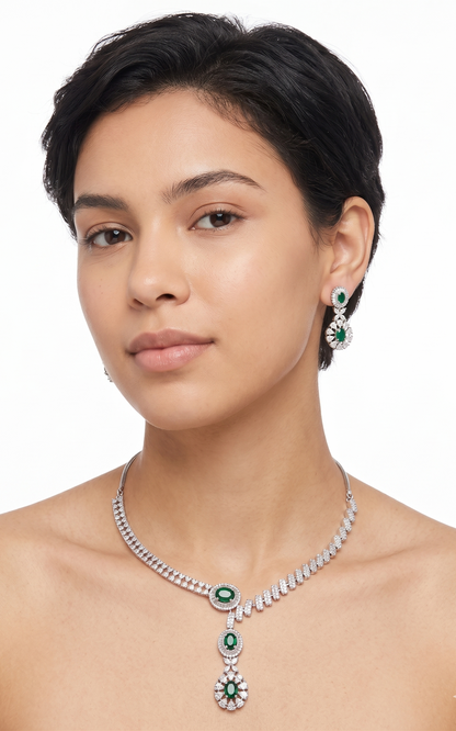 Woman wearing a silver necklace with green gemstones on a white background