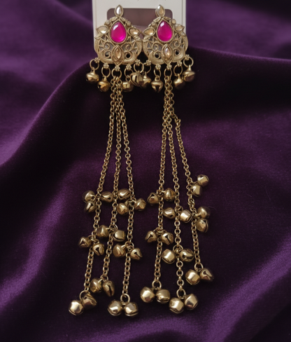 Close-up view of premium artificial Antique Gold Tone Long Tassel Ghungroo Earrings with Rani Pink Stone Accents by Innovate Art Impex.