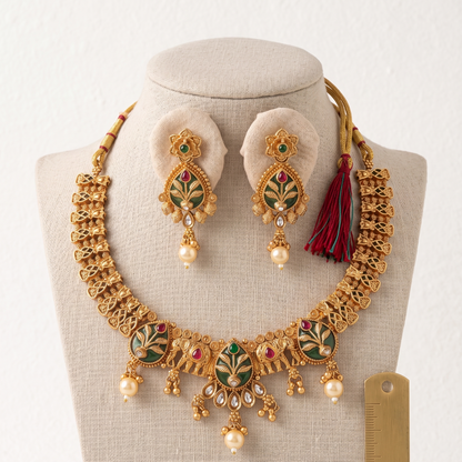 Gold necklace and earrings set on a mannequin with a white background