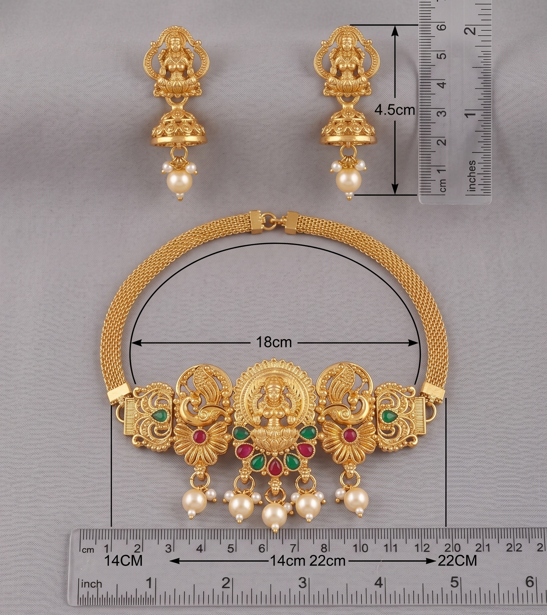 Gold necklace and earrings with measurements on a gray background