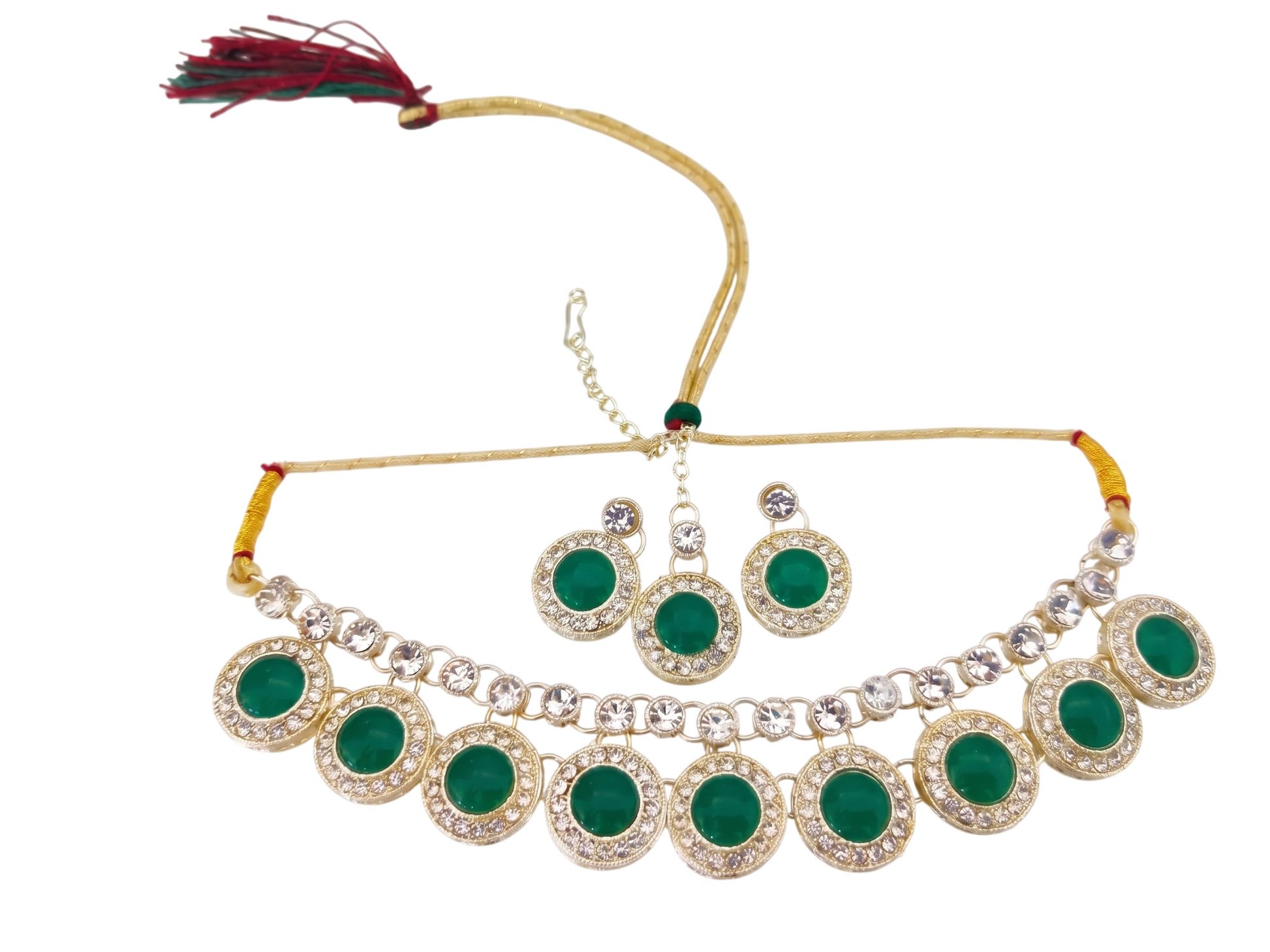 Top-down view of 3-piece green jewelry set with necklace, earrings, and Maang Tikka on marble.